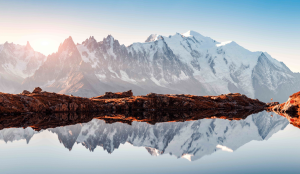 View of the Mont Blanc summits in snow reflected also on the Lac Blanc surface in fold morning light on Tour du Mont Blanc trekking trail