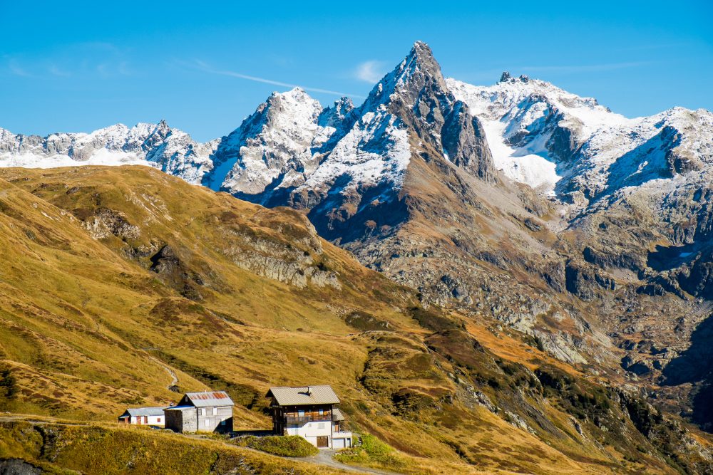 Rustic alpine sheds with snowy Mont Blanc in the horizon, taken from the TMB hiking trail