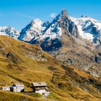 Rustic alpine sheds with snowy Mont Blanc in the horizon, taken from the TMB hiking trail