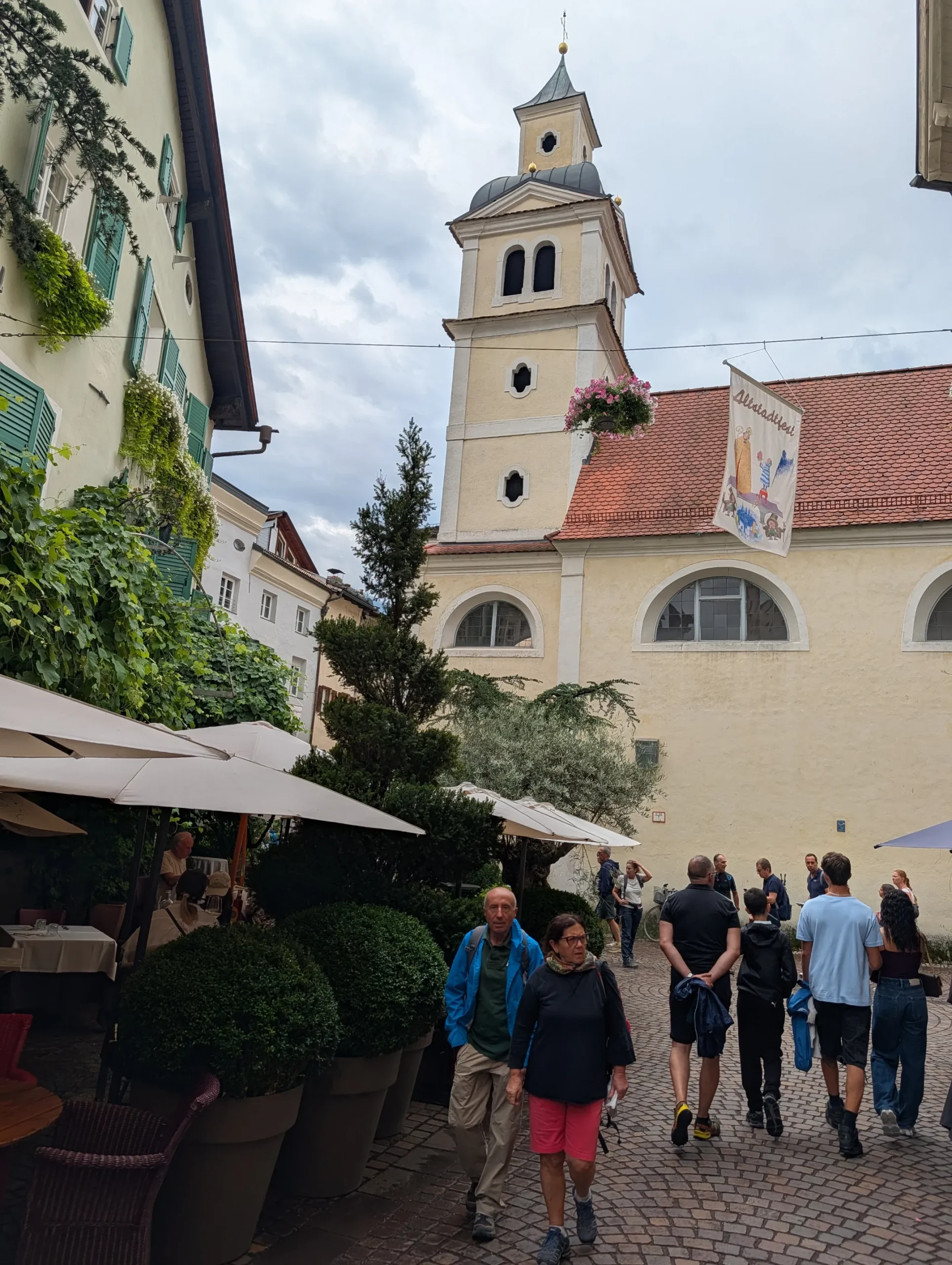 Church tower and passers by in the city of Brixen in Italy