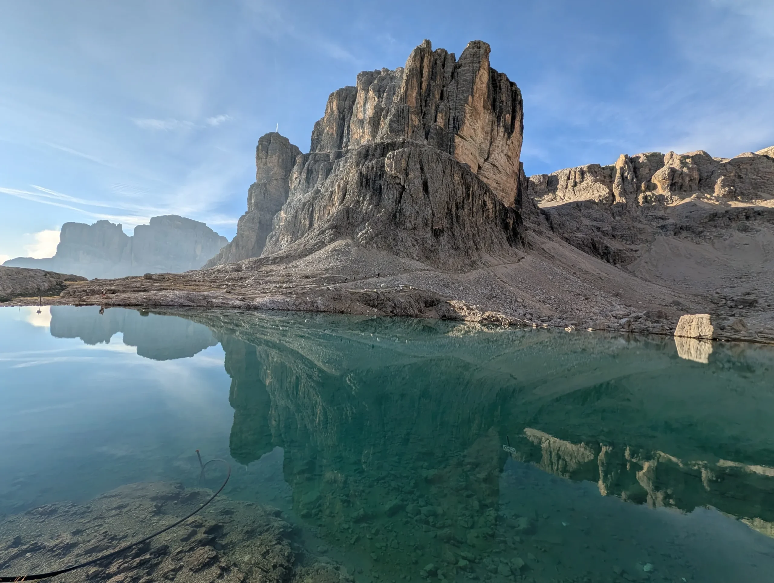Steep Dolomites summits reflected on the turquoise waters of the Lago Pisciadu alpine lake on AV2 trek